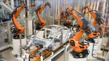 Teile eines Volkswagens werden im Karosseriewerk im Volkswagen Werk Emden von Kuka-Robotern zusammengefügt.