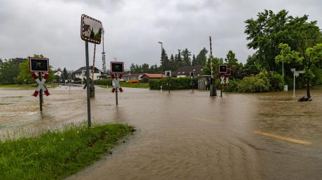In Fischach im schwäbischen Landkreis Augsburg stehen eine Straße udn ein Bahnübergang unter Wasser.
