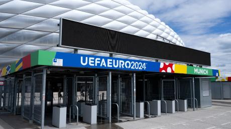 Der Schriftzug «UEFAEURO2024 - MUNICH» ist an einem Eingang von der München Fußball Arena zu sehen.