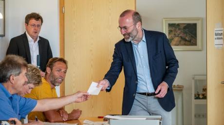 Manfred Weber, Vorsitzender der Europäischen Volkspartei, bekommt in einem Wahllokal seinen Stimmzettel.