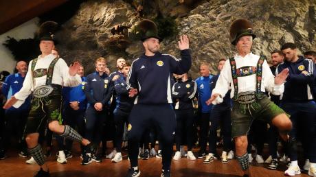 Schottlands John McGinn (M) tanzt mit, als die Mannschaft in der Bayernhalle zu einem Empfang des Bürgermeisters eintrifft.