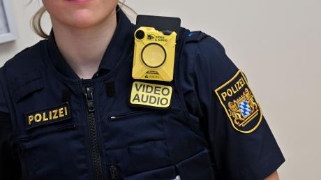 Eine Polizistin trägt nach einer Pressekonferenz eine sogenannte „Bodycam“ an ihrer Uniform.