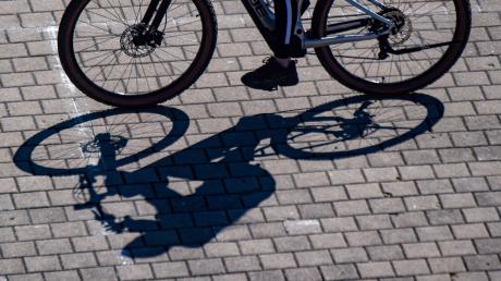 Eine Radfahrerin wirft einen Schatten.