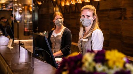 Empfang mit Mundschutz: Noch müssen die Mitarbeiterinnen an der Rezeption des Hotels König Ludwig in Schwangau die Masken tragen. 