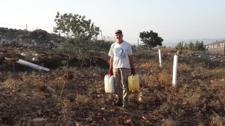 Von Freiwilligen wie Christian Artner-Schedler müssen die Setzlinge von Olivenbäumen per Hand gewässert werden.