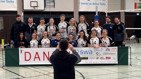 Mit einem "Danke"-Transparent verabschieden sich die Volleyballerinnen der DJK Augsburg-Hochzoll von ihrem Heimpublikum. Abteilungsleiter Fabian Brenner hält das Erinnerungsbild fest. 