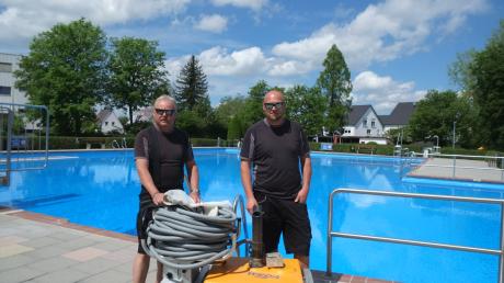 Die Bademeister Walter Senftleben (links) und Daniel Stöckl (rechts) müssen noch vor der Eröffnung des Freibads das Becken mit dem Bodensauger reinigen. 