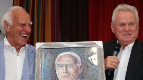 Franz "Bulle" Roth und Sepp Maier mit einem Gemälde des im Januar 2024 verstorbenen "Kaiser" Franz Beckenbauer.