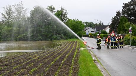 Überlastete Kanäle fluteten beim Hochwasser in Mering ganze Straßen. Das Bild zeigt die Helfer aus Schweinfurth, die dabei helfen, das Wasser aus der Glücksstraße abzupumpen. 