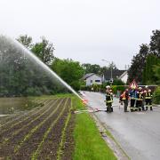 Überlastete Kanäle fluteten beim Hochwasser in Mering ganze Straßen. Das Bild zeigt die Helfer aus Schweinfurth, die dabei helfen, das Wasser aus der Glücksstraße abzupumpen. 