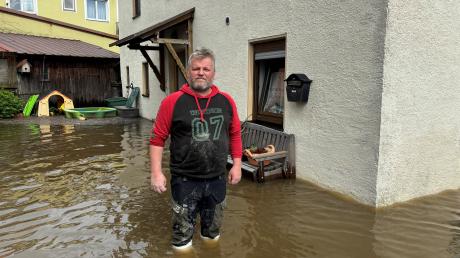 Manfred Mayr steht am Sonntag vor seinem Haus in der Badgasse im Wasser.