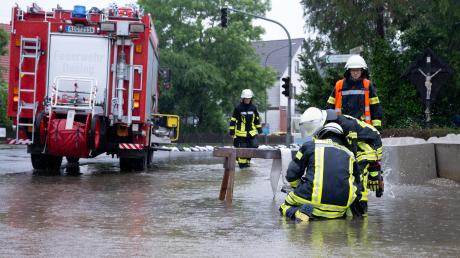 Seit Samstag sind 500 Einsatzkräfte in Aichach-Friedberg im Dauereinsatz gegen das Hochwasser. Hier pumpen Feuerwehrleute und Helfer Wasser von einer Straße in Dasing. 