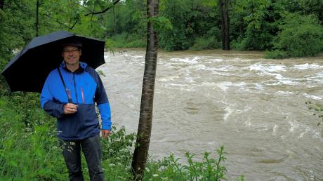 Leo Rasch vor der Kulisse einer reißenden Wertach am vergangenen Hochwasser-Wochenende. Der Fluss fließt bei Türkheim in einem tiefen, betonierten Bett östlich am Ort vorbei. Die Wertachfreunde wollen den Fluss aus diesem Korsett befreien.