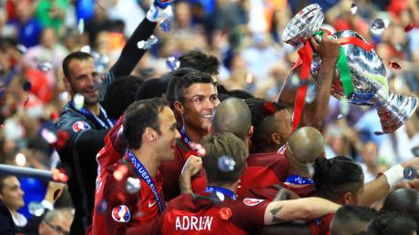 Fußball-Europameister Cristiano Ronaldo inmitten seines Teams mit dem EM-Pokal in Paris 2016.