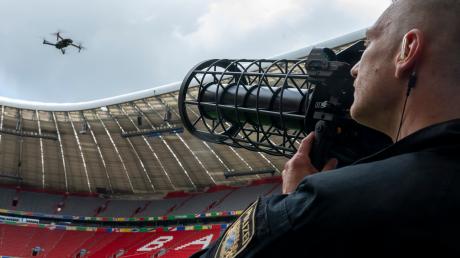 Ein speziell ausgebildeter Polizist zeigt während der Vorstellung des Münchner Sicherheitskonzepts zur Fußball-Europameisterschaft im Fußballstadion München eine kontrollierte Landung einer Drohne, mittels Drohnen-Jammer.