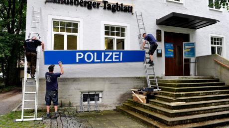 Nicht verwirren lassen: Probeweise hängen die Männer der „Grizzly FIlmbau GmbH“ das Polizeischild an das Redaktionsgebäude des Landsberger Tagblatts. 