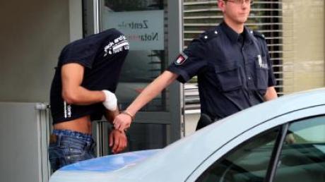 Ein Polizist führt in Hamburg den mutmaßlichen Täter ab