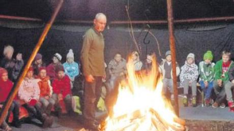Rund um das Feuer im Märchenzelt lauschen die Erst- bis Viertklässler aus Rammingen gespannt der Geschichte des Märchenerzählers Matthias Fischer. 