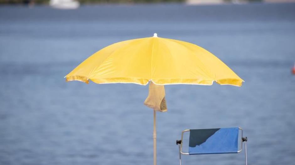 Ein Sonnenschirm steht an einem Strand am Altmühlsee. Tief "Jantra" am Wochenende für einen grundlegenden Wetterwechsel.