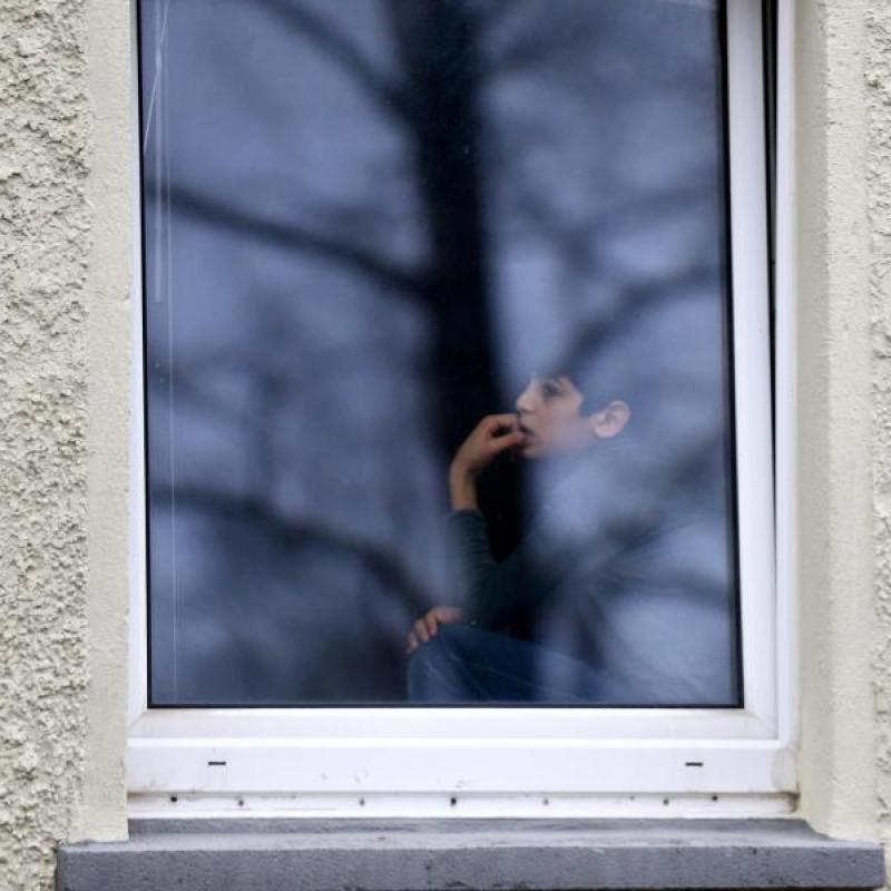 Der Flüchtlingsjunge Ramzi Khatoum schaut aus dem Fenster einer Unterkunft in Clausnitz.