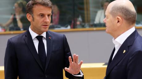 Emmanuel Macron (l), Präsident von Frankreich, spricht mit Bundeskanzler Olaf Scholz.